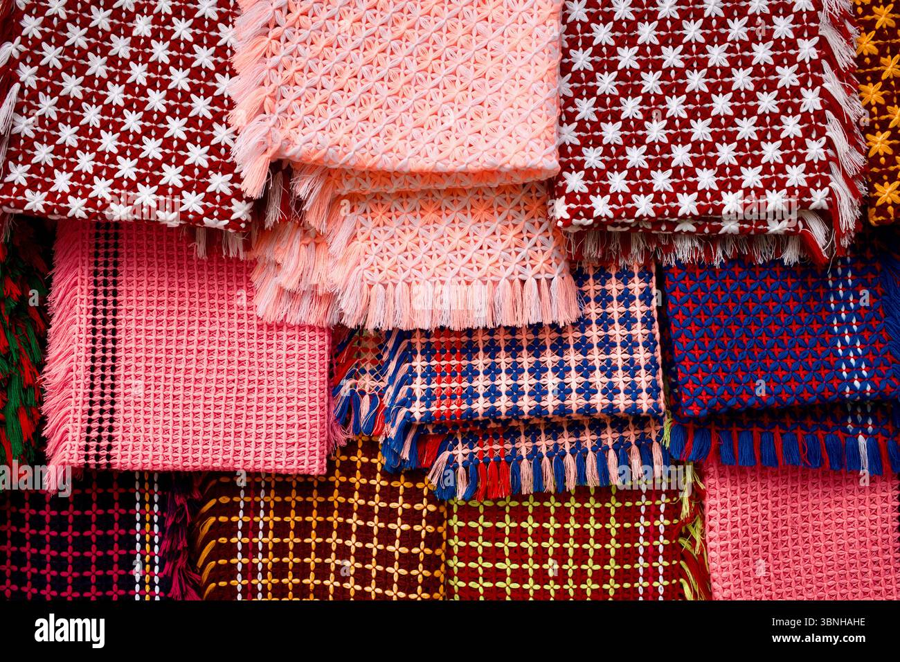 Couvertures fabriquées à la main par des artisans de Rakhine à Kuakata, au Bangladesh, mettant en valeur des broderies géométriques vibrantes et des techniques traditionnelles de métier à tisser. Banque D'Images