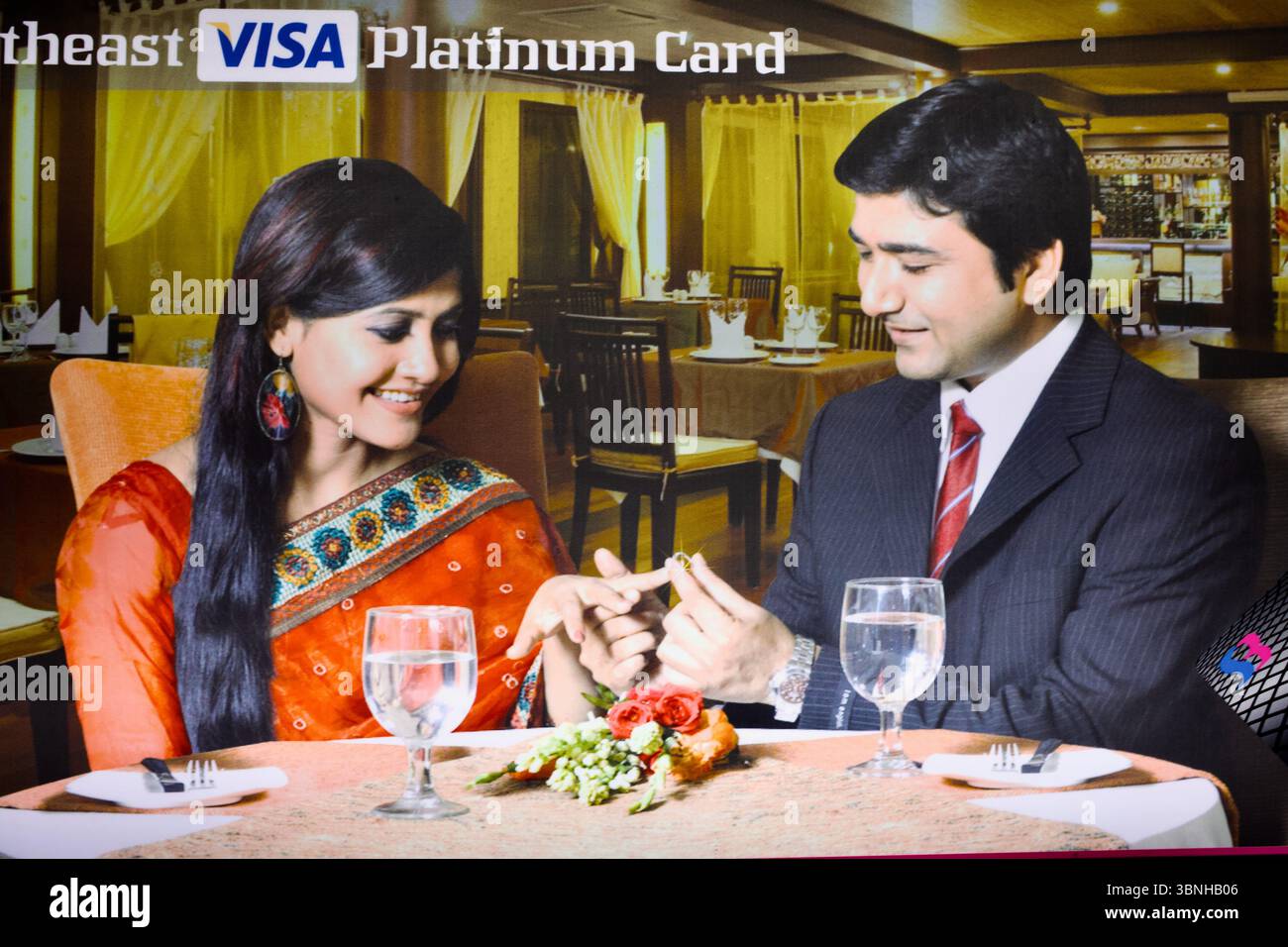 Publicité bangladaise pour VISA Platinum Card représentant un couple de classe moyenne supérieure échangeant une bague au cours d'un dîner dans un cadre de luxe stylisé. Banque D'Images