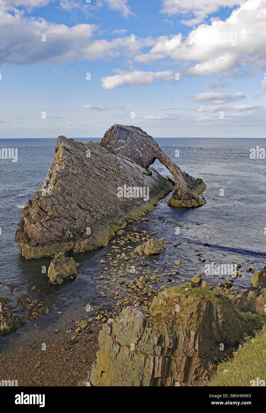 Formation rocheuse remarquable avançant dans la mer sous un ciel bleu avec peu de nuages, Bow Fiddle Rock, Aberdeenshire, Buckie, Écosse, Royaume-Uni, EUR Banque D'Images