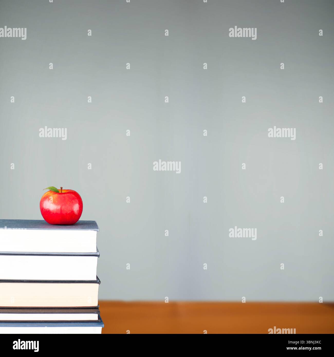 Red Apple on pile of books in classroom Banque D'Images