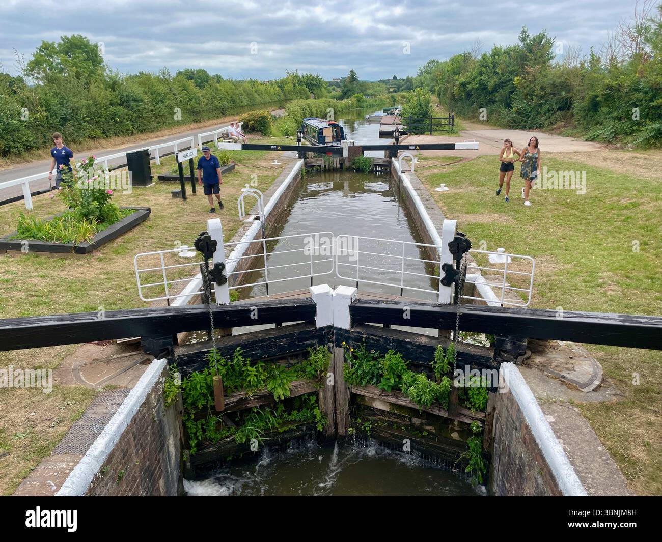 serrure de maunsel dans le somerset angleterre sur le canal bridgwater taunton- un groupe d'une barge à peu près ouvert la vieille porte de serrure en bois couverte de mauvaises herbes verdoyantes Banque D'Images
