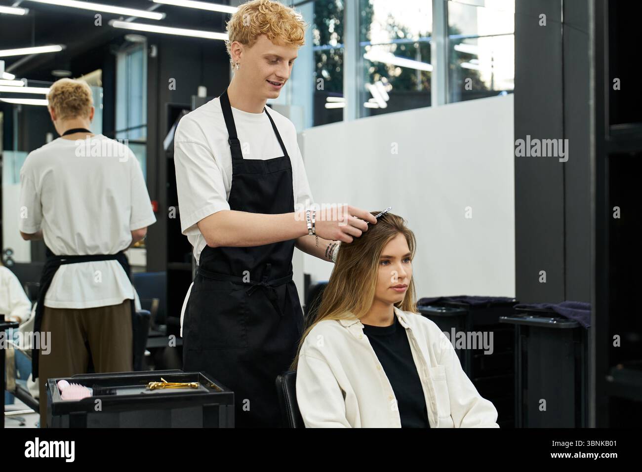Stylistes s'engagent avec les clients dans un salon de beauté dynamique mettant l'accent sur les tendances actuelles dans les coiffures. Banque D'Images