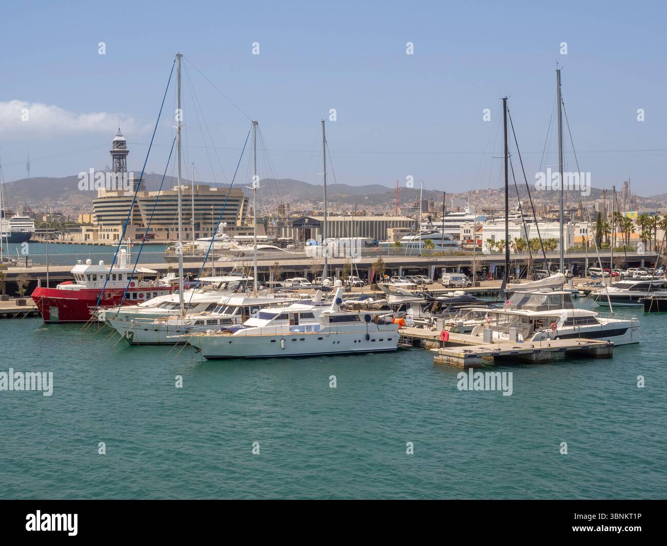 Yachts et bateaux amarrés à la marina de Port Vell avec l'horizon de Barcelone et Montjuïc en arrière-plan, Barcelone, Espagne. Banque D'Images