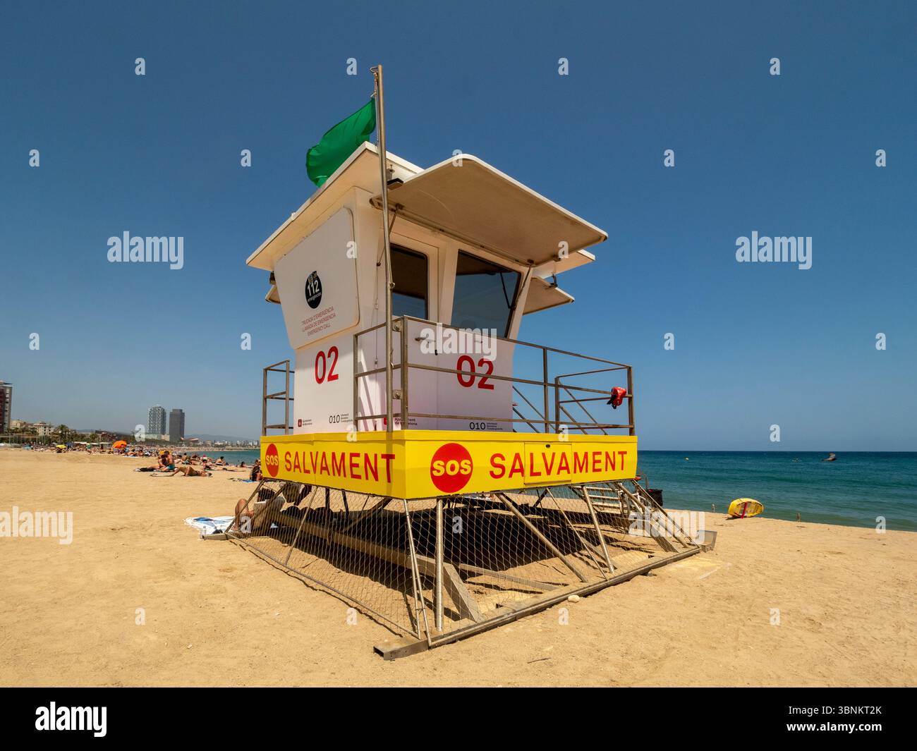 Une tour de sauveteur sur une plage de Barcelone, avec un drapeau vert indiquant des conditions de baignade sûres. Espagne. Banque D'Images