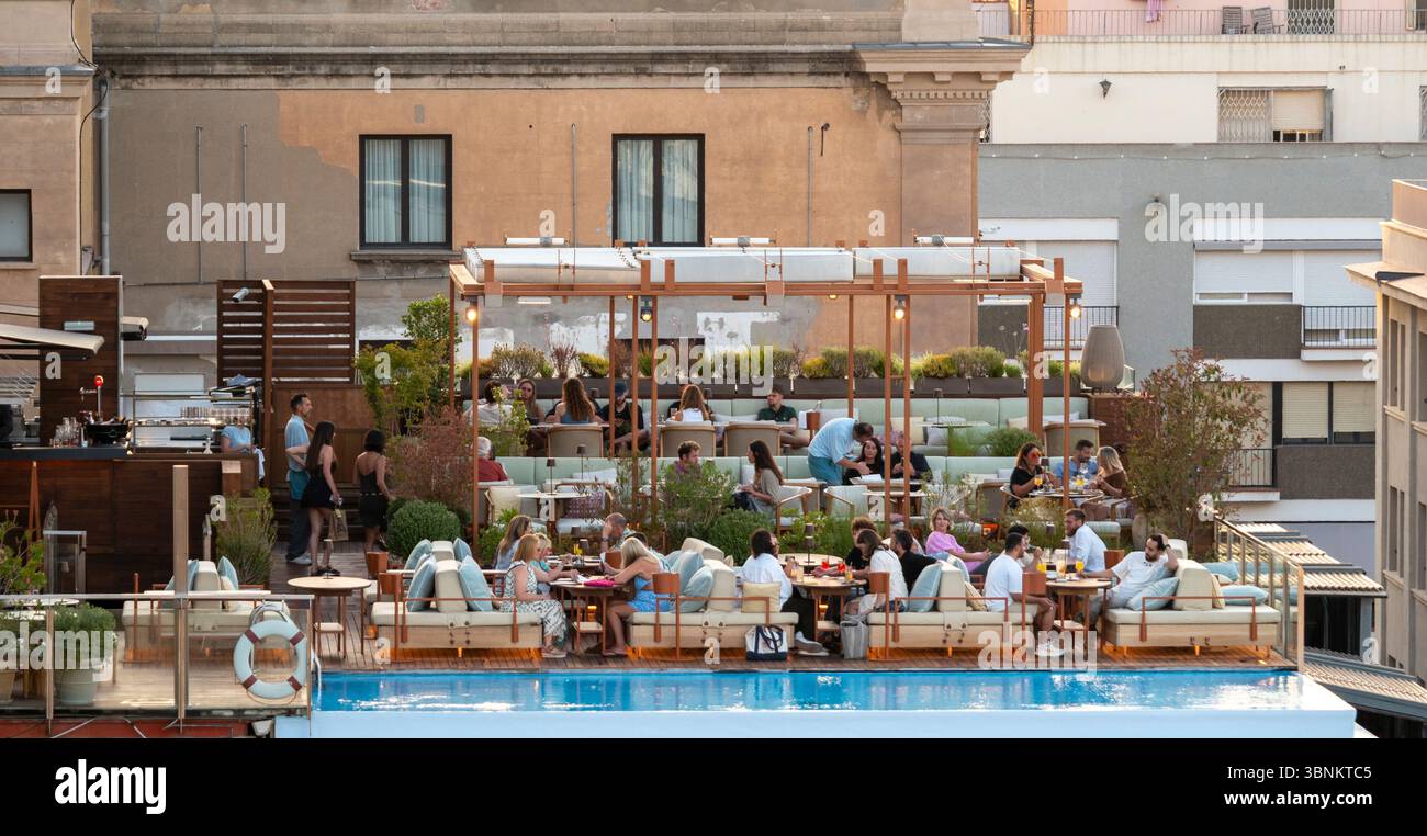 Les gens se détendent et socialisent au bord d'une piscine dans un bar chic sur le toit à Barcelone. Espagne Banque D'Images