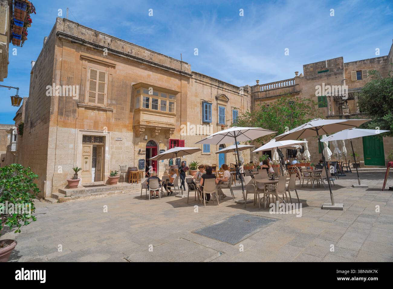Café Mdina Malte, vue de touristes assis à des tables à l'extérieur du bar à vin Don Mesquito café populaire dans le Pjzazza Mesquito dans la ville fortifiée de Mdina. Banque D'Images