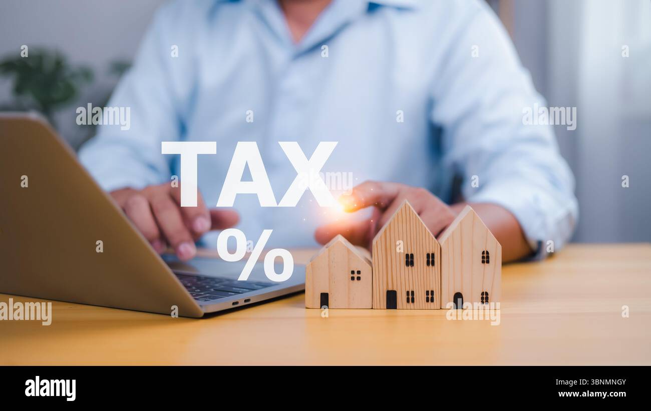 Personne interagissant avec le texte holographique TAX % et les modèles de maison en bois, symbolisant l'impôt foncier, l'investissement immobilier, la propriété, la fiscalité, an Banque D'Images