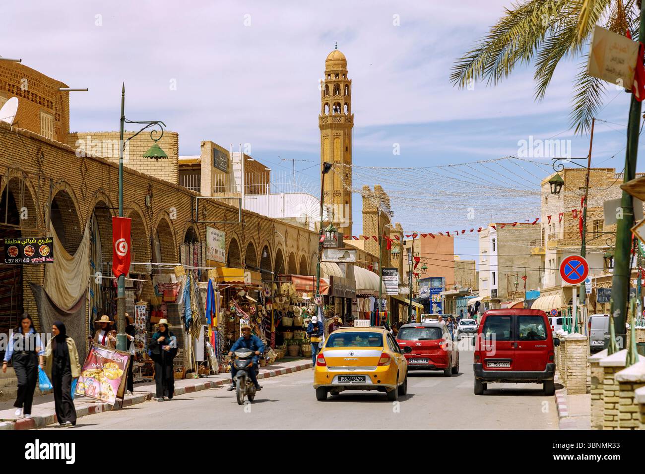 Rue principale Avenue Abdul Kacem Chebbi avec vue sur la mosquée Ferkous dans le centre de Tozeur, Tunisie Banque D'Images