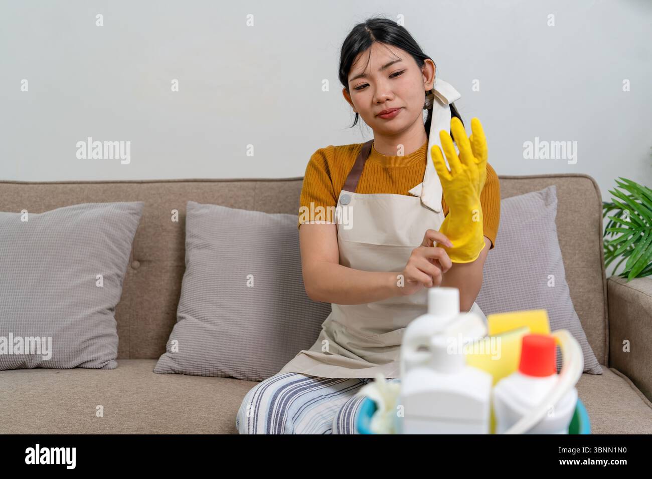 Femme au foyer asiatique activement engagée dans les tâches ménagères quotidiennes, telles que le nettoyage, l'organisation ou le rangement de sa maison. Banque D'Images