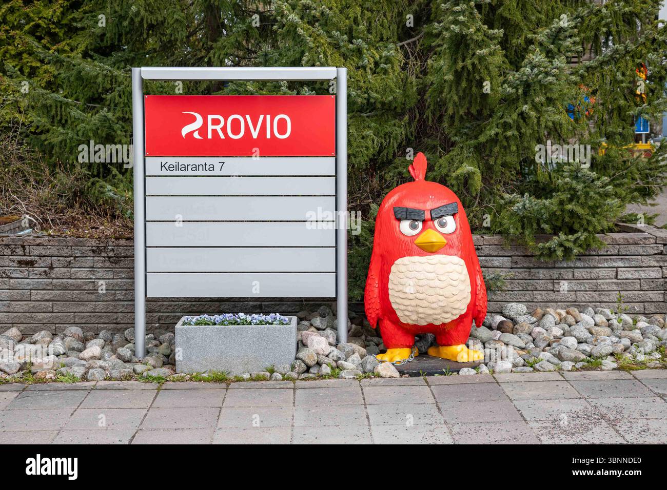 Figure rouge (d'Angry Birds) debout près du panneau du siège de Rovio à Keilaranta 7 dans le district de Keilaniemi d'Espoo, Finlande Banque D'Images