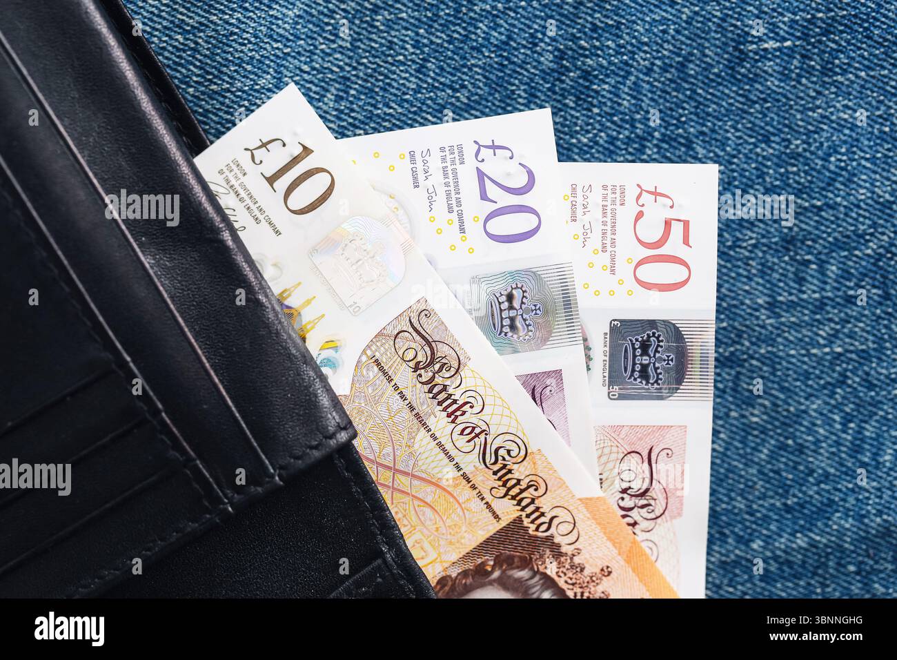Billets de banque britanniques dans le portefeuille. Dix billets de vingt et cinquante livres partiellement visibles. Monnaie britannique sur fond denim. Concept financier. Argent personnel. Banque D'Images