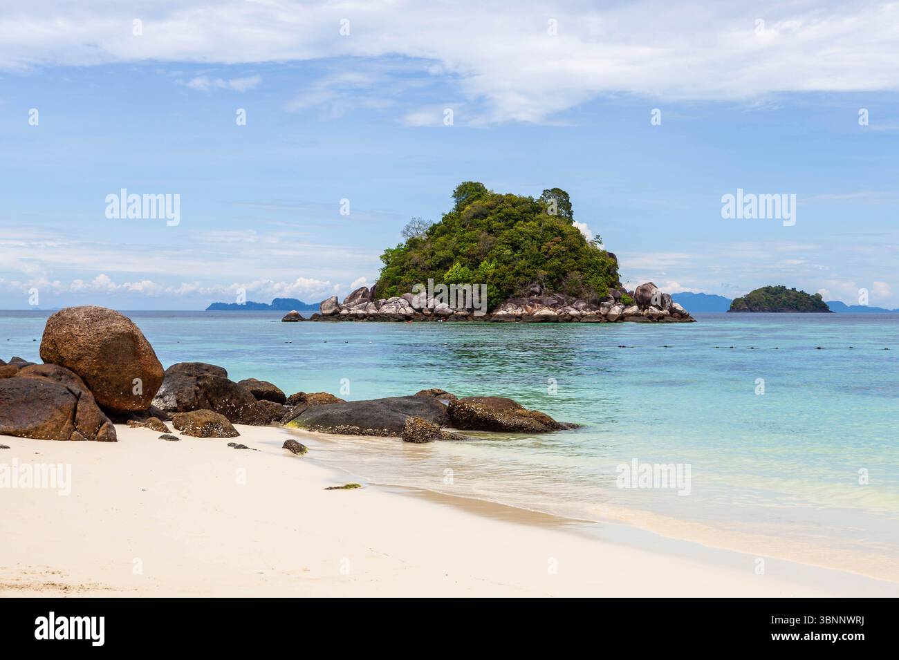 Koh Lipe, Thaïlande. Mer d'Andaman et Ko Usen petit îlot vue de l'île. Plage de sable avec quelques rochers. Paysage tropical. Banque D'Images