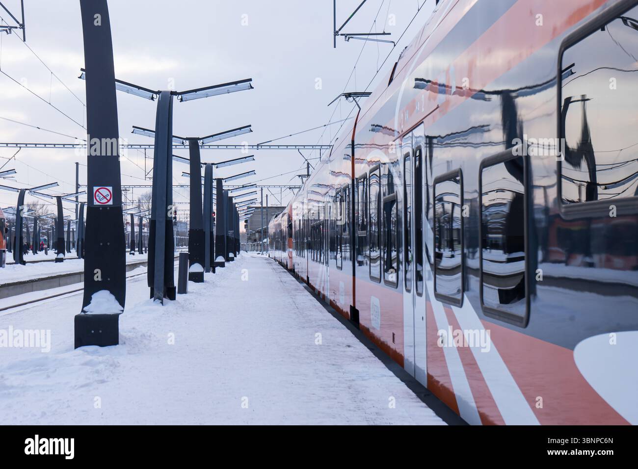 Train Elron moderne sur une plate-forme enneigée à Tallinn, Estonie, en hiver. Scène des transports publics urbains. Banque D'Images