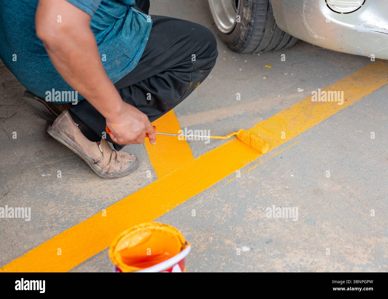 Les lignes des aires de stationnement sont repeintes par les travailleurs. Banque D'Images