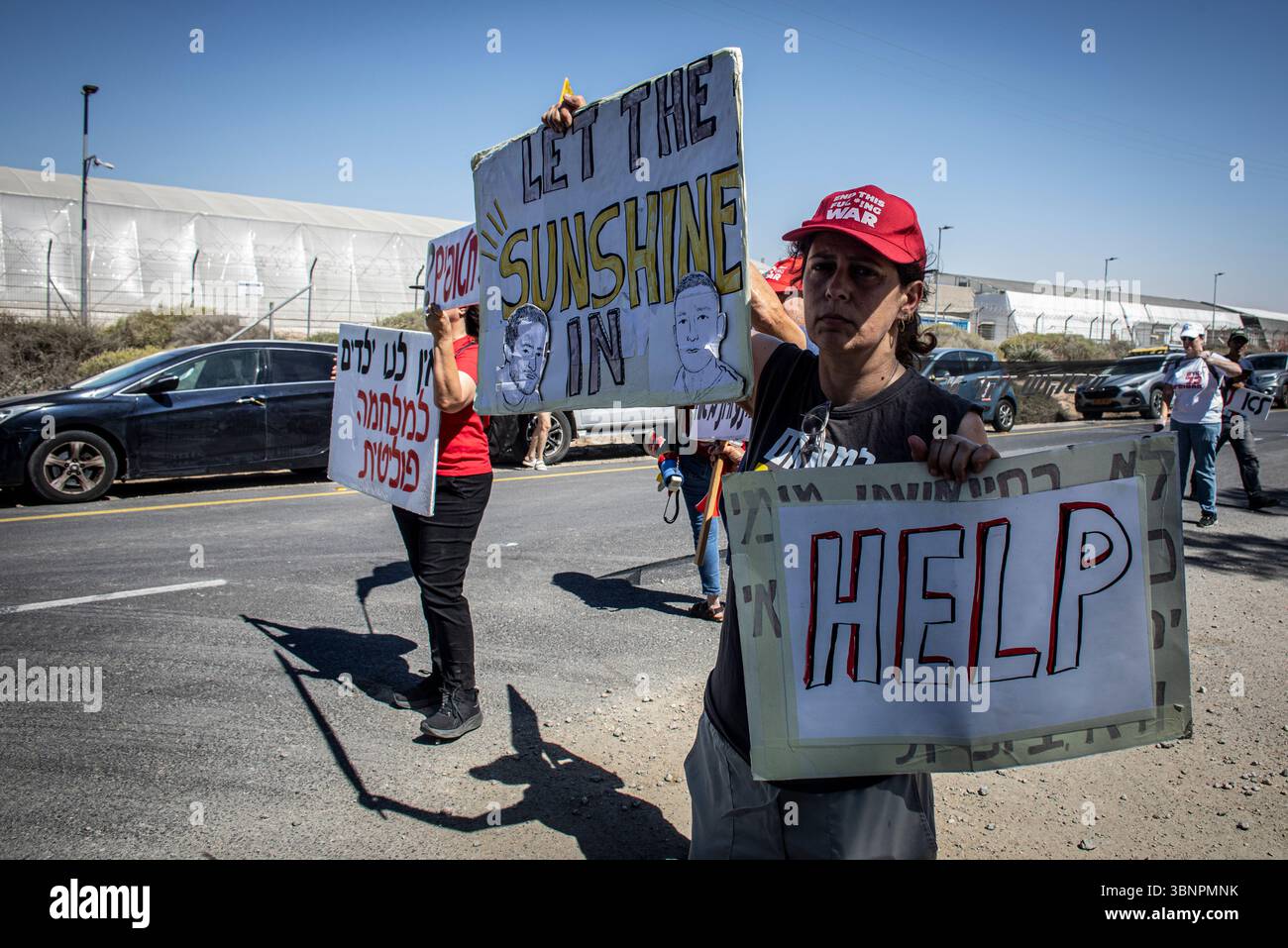 Un manifestant brandit des pancartes à l'entrée du kibboutz Nir Oz avant la visite du premier ministre israélien Benjamin Netanyahu, jeudi 3 juillet 2025. Netanyahu a effectué sa première visite depuis le massacre du 7 octobre dans la communauté frontalière de Gaza du kibboutz Nir OzÑnearly 21 mois après l’assaut mené par le Hamas qui a laissé un résident sur quatre assassiné ou kidnappedÑand a été accueilli à l’entrée par une pancarte indiquant ÒMr. AbandonmentÓ et par des survivants en colère l'accusant de chercher la rédemption politique sans jamais reconnaître l'échec de stateÕs à les protéger. Photo par Eyal Warshavsky. Banque D'Images