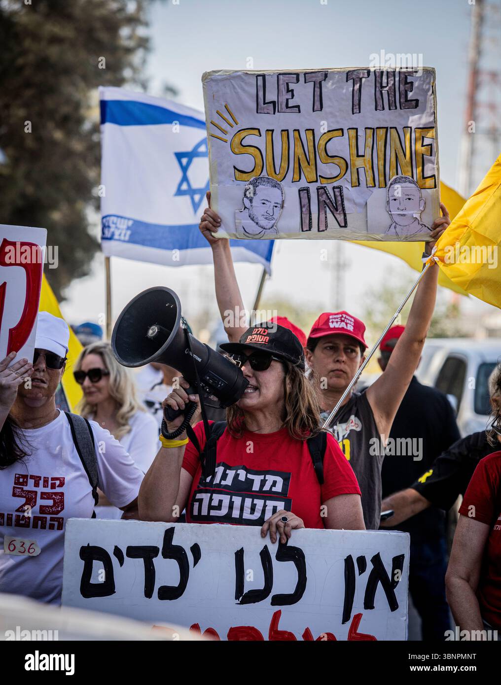 Les manifestants chantent et brandissent des pancartes à l’entrée du kibboutz Nir Oz avant la visite du premier ministre israélien Benjamin Netanyahu, jeudi 3 juillet 2025. Netanyahu a effectué sa première visite depuis le massacre du 7 octobre dans la communauté frontalière de Gaza du kibboutz Nir OzÑnearly 21 mois après l’assaut mené par le Hamas qui a laissé un résident sur quatre assassiné ou kidnappedÑand a été accueilli à l’entrée par une pancarte indiquant ÒMr. AbandonmentÓ et par des survivants en colère l'accusant de chercher la rédemption politique sans jamais reconnaître l'échec de stateÕs à les protéger. Photo par Eyal Warshavsky. Banque D'Images