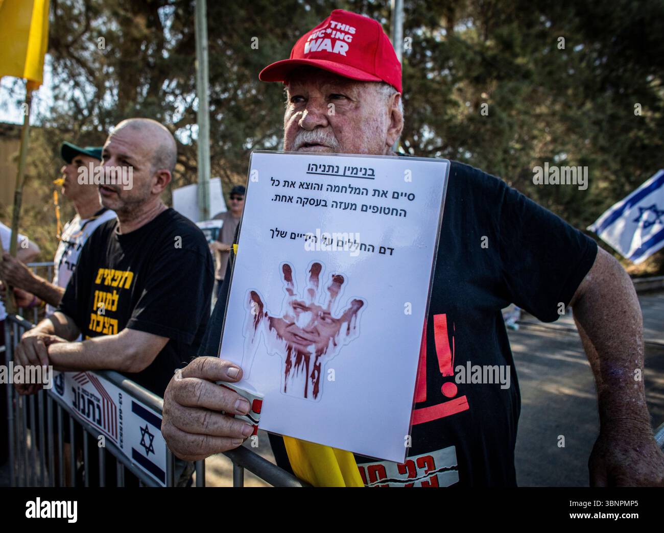 Un manifestant tient une pancarte montrant le premier ministre israélien Benjamin Netanyahu, à l'entrée du kibboutz Nir Oz avant la visite de Netanyahu, jeudi 3 juillet 2025. Netanyahu a effectué sa première visite depuis le massacre du 7 octobre dans la communauté frontalière de Gaza du kibboutz Nir OzÑnearly 21 mois après l’assaut mené par le Hamas qui a laissé un résident sur quatre assassiné ou kidnappedÑand a été accueilli à l’entrée par une pancarte indiquant ÒMr. AbandonmentÓ et par des survivants en colère l'accusant de chercher la rédemption politique sans jamais reconnaître l'échec de stateÕs à les protéger. Photo de Eyal Warshavsk Banque D'Images