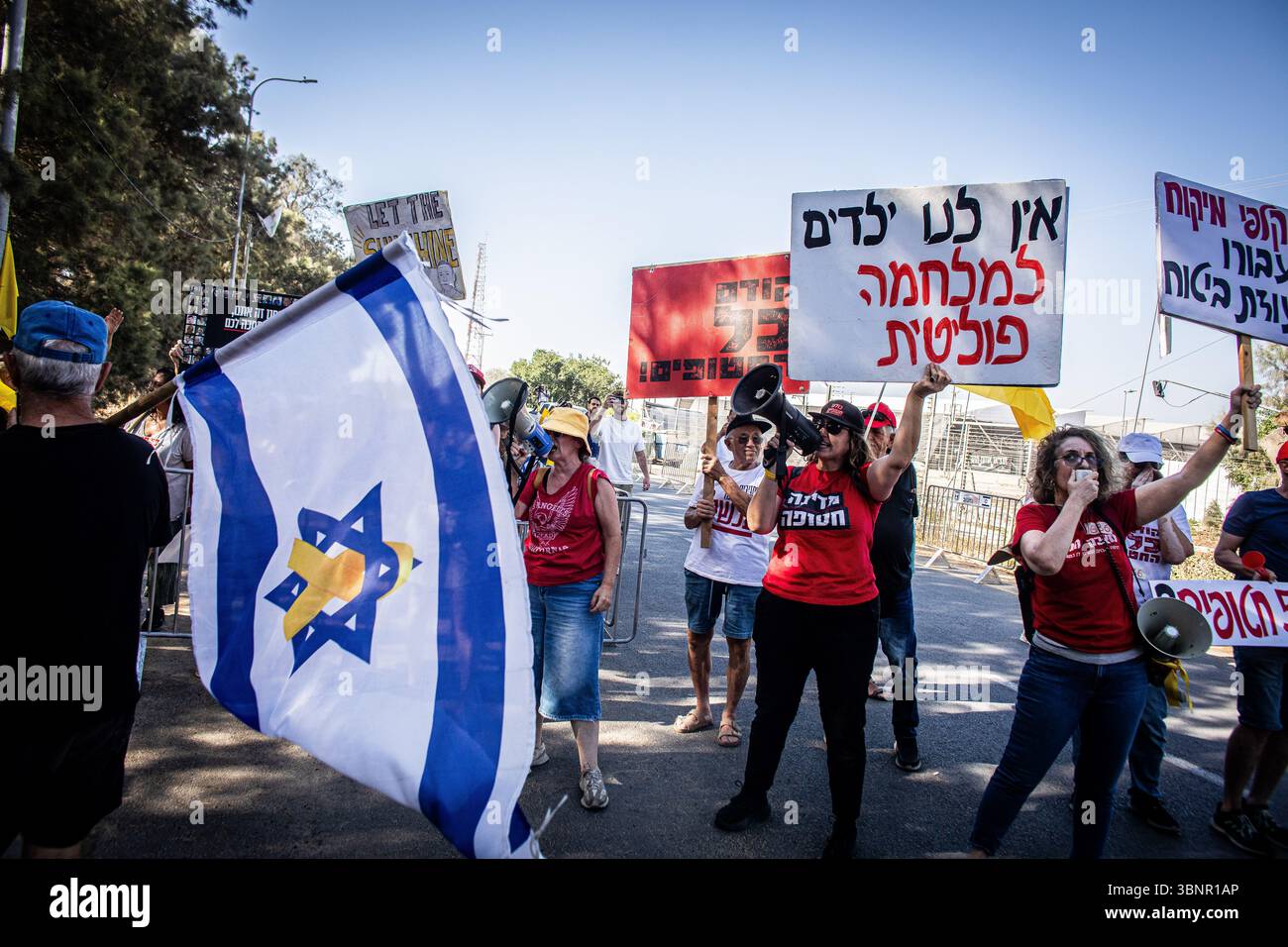 Les manifestants scandent des slogans et tiennent des pancartes à l'entrée du kibboutz Nir Oz avant la visite du premier ministre israélien Benjamin Netanyahu. Netanyahu a effectué sa première visite depuis le massacre du 7 octobre dans la communauté frontalière de Gaza du kibboutz Nir Oz près de 21 mois après l’assaut mené par le Hamas qui a laissé un résident sur quatre assassiné ou enlevé et a été accueilli à l’entrée par une pancarte indiquant Mr. abandon et par des survivants en colère l’accusant de chercher la rédemption politique sans jamais reconnaître l’incapacité des états à les protéger. Banque D'Images