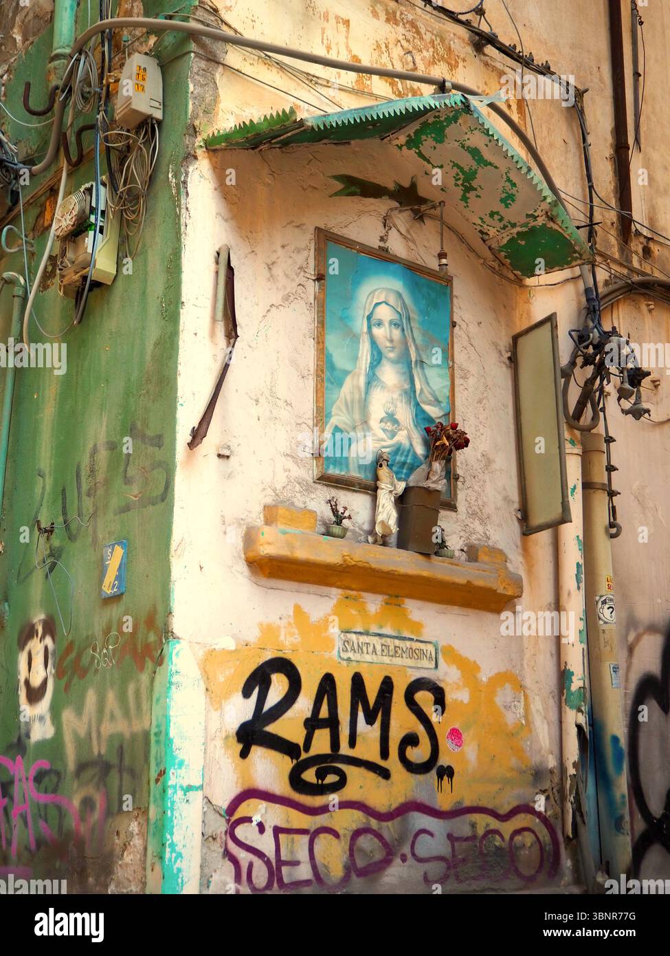 Mur couvert de graffitis avec sanctuaire de la Vierge Marie sur un coin de rue à Palerme, Sicile Banque D'Images