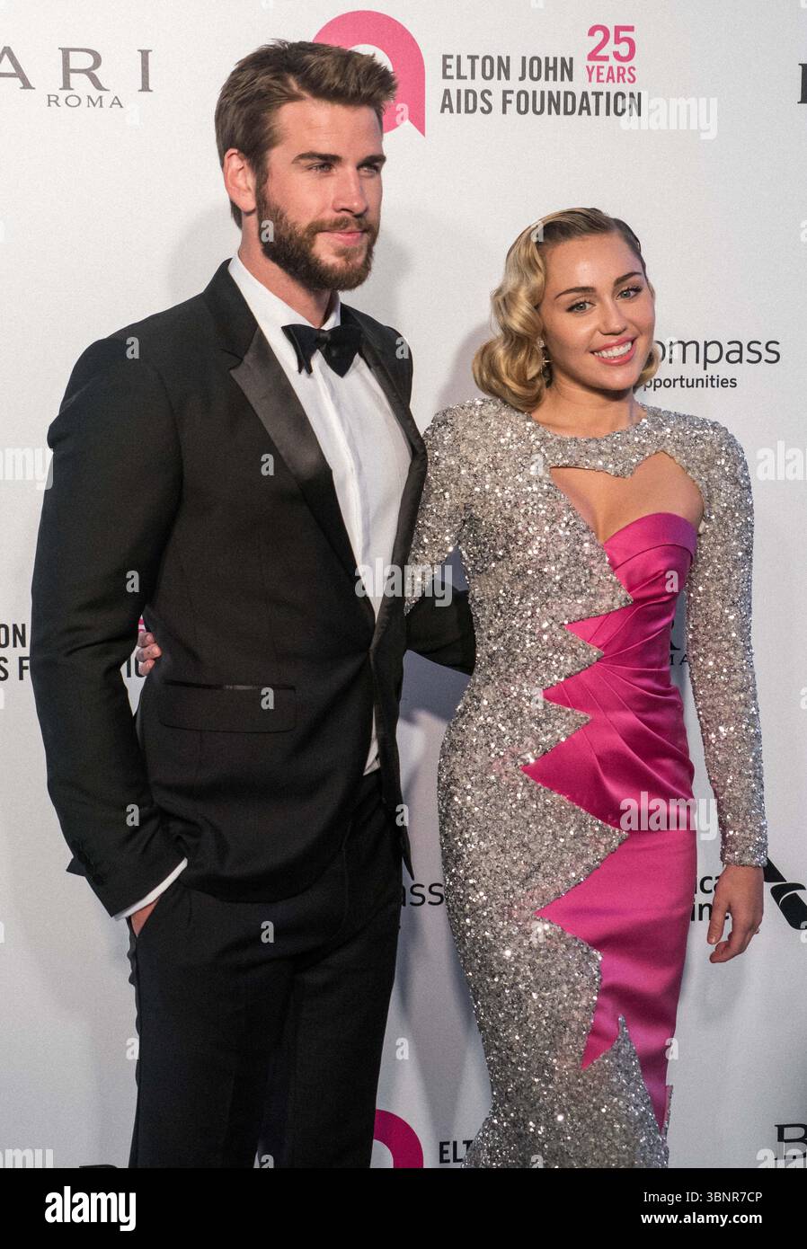 (FILE) Miley Cyrus recevra une étoile sur le Hollywood Walk of Fame en 2026. Miley Cyrus fait partie des 35 lauréats annoncés le mercredi 2 juillet 2025 par Eugenio Derbez et Richard Blade. WEST HOLLYWOOD, LOS ANGELES, CALIFORNIE, États-Unis - MARS 04 : L'acteur australien Liam Hemsworth portant un tux Burberry et sa petite amie/chanteuse américaine, auteur-compositeur et actrice Miley Cyrus portant une double robe rose et scintillante Moschino arrive à la 26e soirée annuelle des Oscars de la Fondation Elton John AIDS qui s'est tenue au City of West Hollywood Park le 4 mars 2018 à West Hollywood, Los Angeles, Californie, Unit Banque D'Images