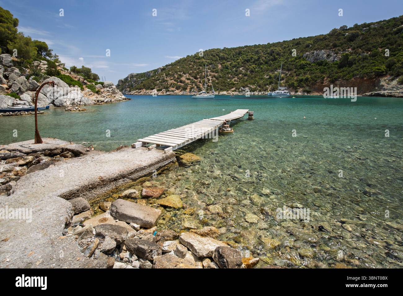 Jetée sur l'eau cristalline à la plage de Vagionia Bay, Poros, Golfe Saronique, îles grecques, Grèce, Europe Banque D'Images
