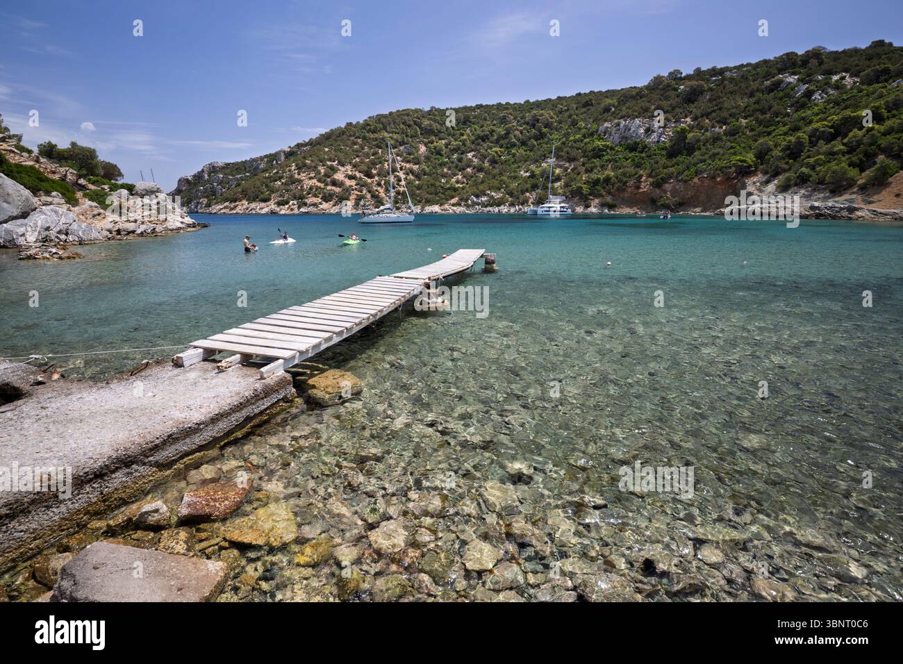 Jetée sur l'eau cristalline à la plage de Vagionia Bay, Poros, Golfe Saronique, îles grecques, Grèce, Europe Banque D'Images