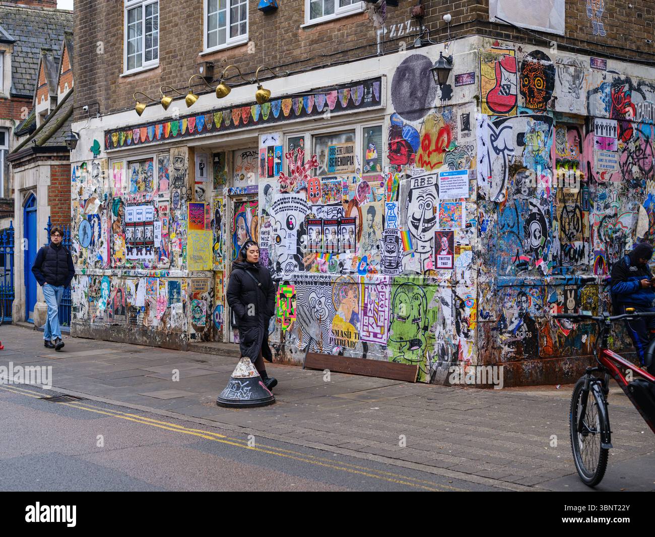 Royaume-Uni, Londres, 07 juillet 2025. Bâtiment d'angle recouvert de graffitis à Shoreditch, dans l'est de Londres, présentant des arts de rue dynamiques, des affiches et des autocollants Banque D'Images