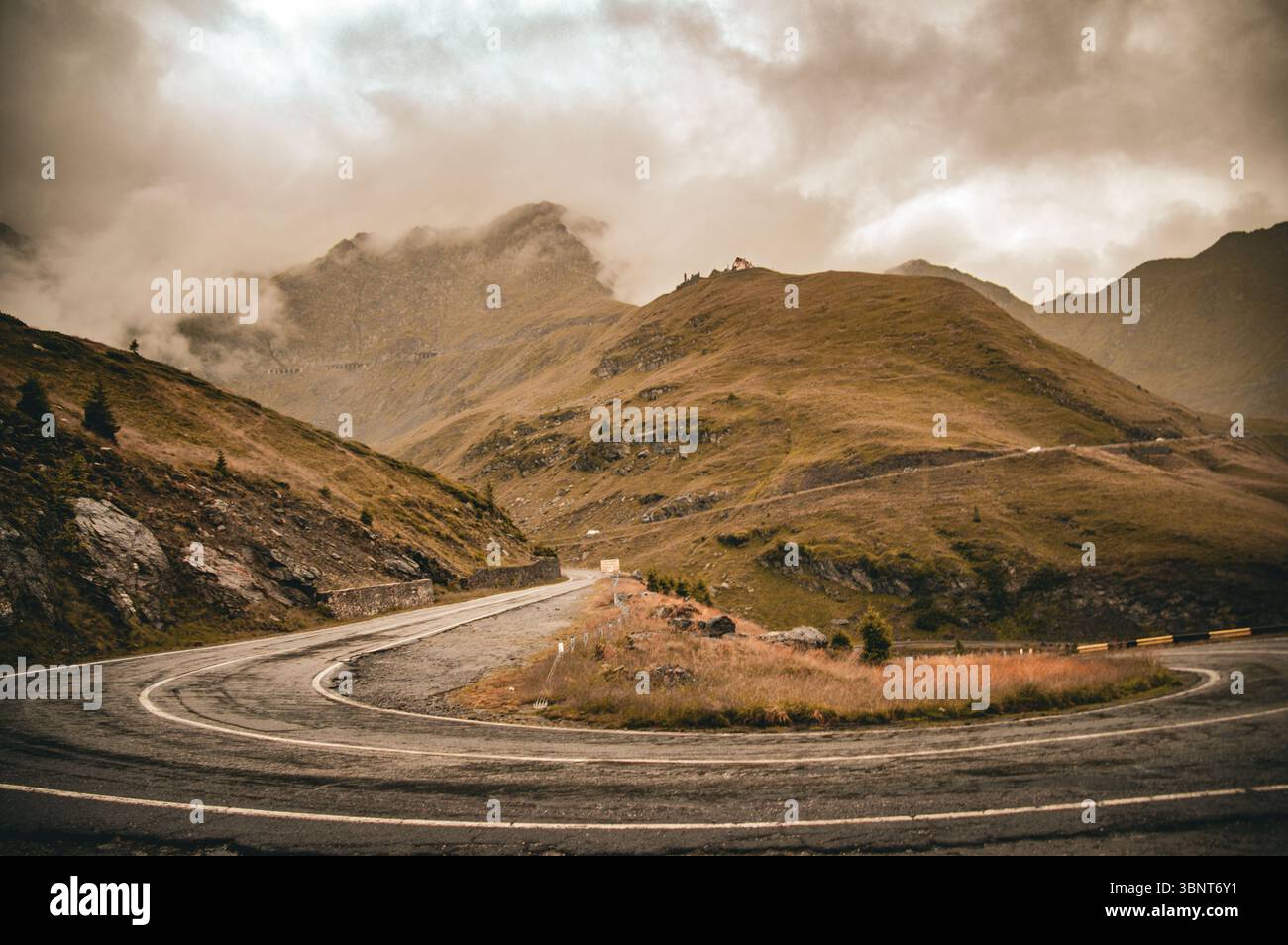 Route de montagne à travers la vallée pittoresque avec ciel nuageux Banque D'Images