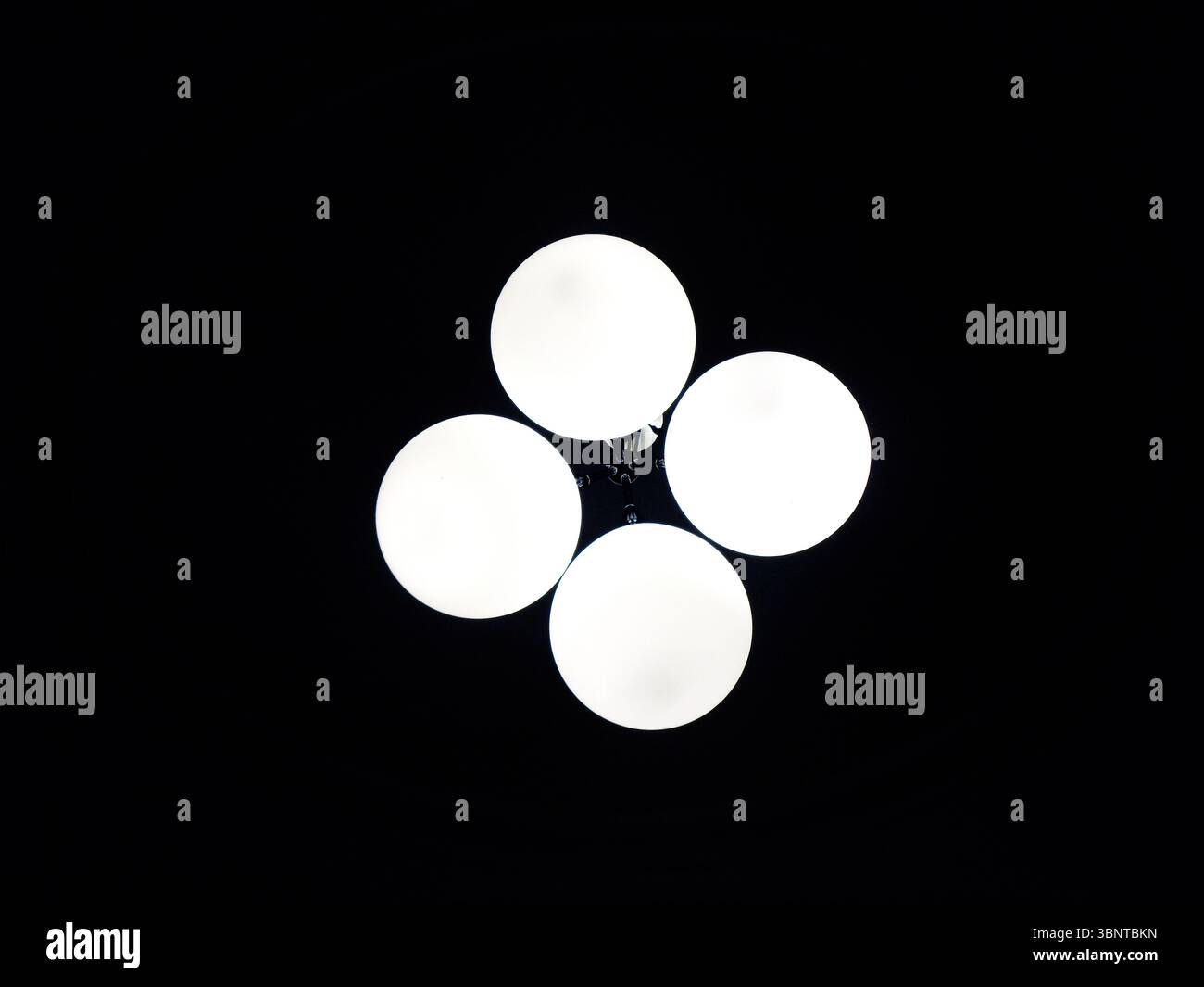 Quatre plafonniers ronds dans l'obscurité Banque D'Images