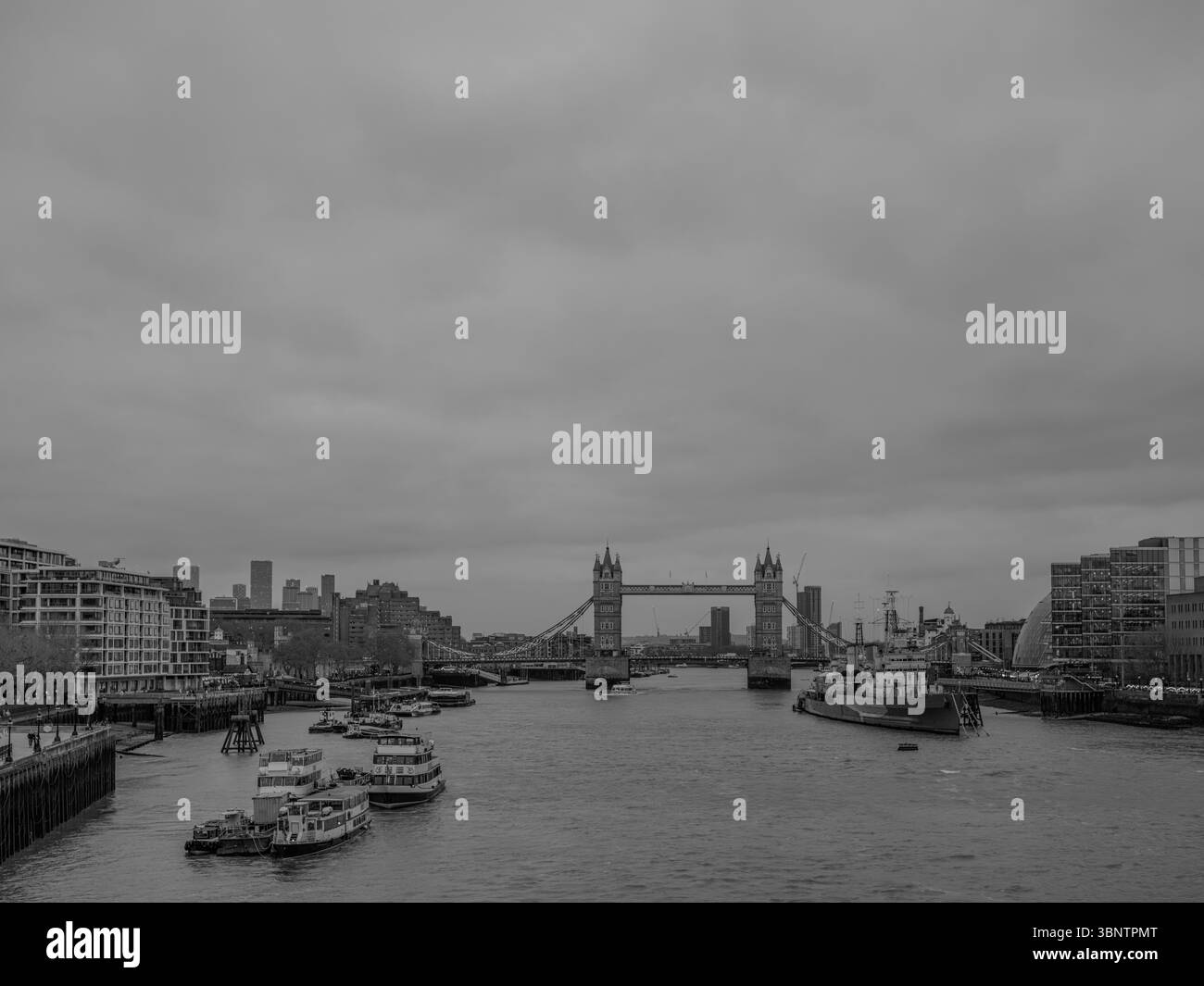 Royaume-Uni, Londres, 11 décembre 2024. Vue sur Tower Bridge et la Tamise par une journée nuageuse d'hiver avec des bateaux amarrés le long de la rivière Banque D'Images