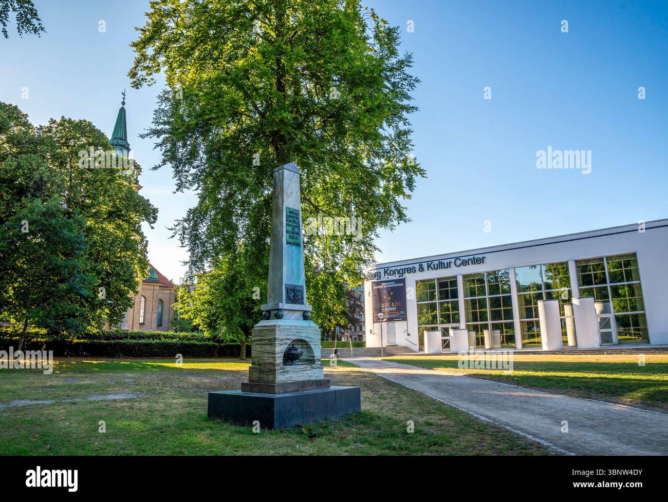 Monument historique de l'obélisque devant l'église d'Ansgar et le bâtiment du centre culturel moderne dans le parc Kildeparken, Aalborg, Danemark, 16 juillet 2018 Banque D'Images