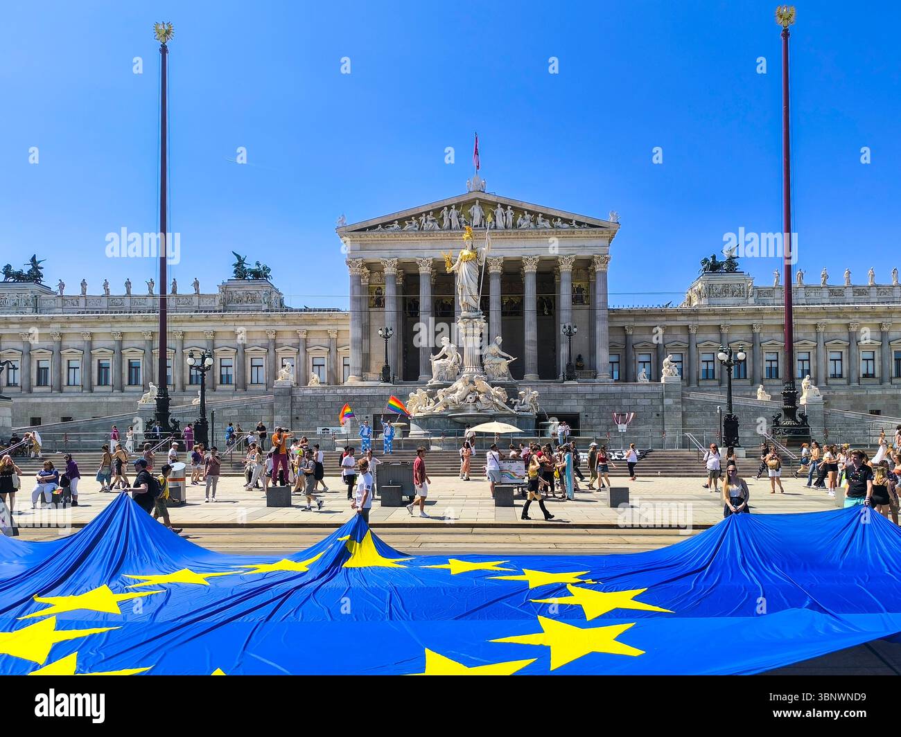 Vienne, Autriche, 06.14.2025, des personnes brandissent le drapeau géant de l'UE et brandissent des drapeaux LGBTQ devant le bâtiment du Parlement autrichien lors de la marche de la Pride Day Banque D'Images