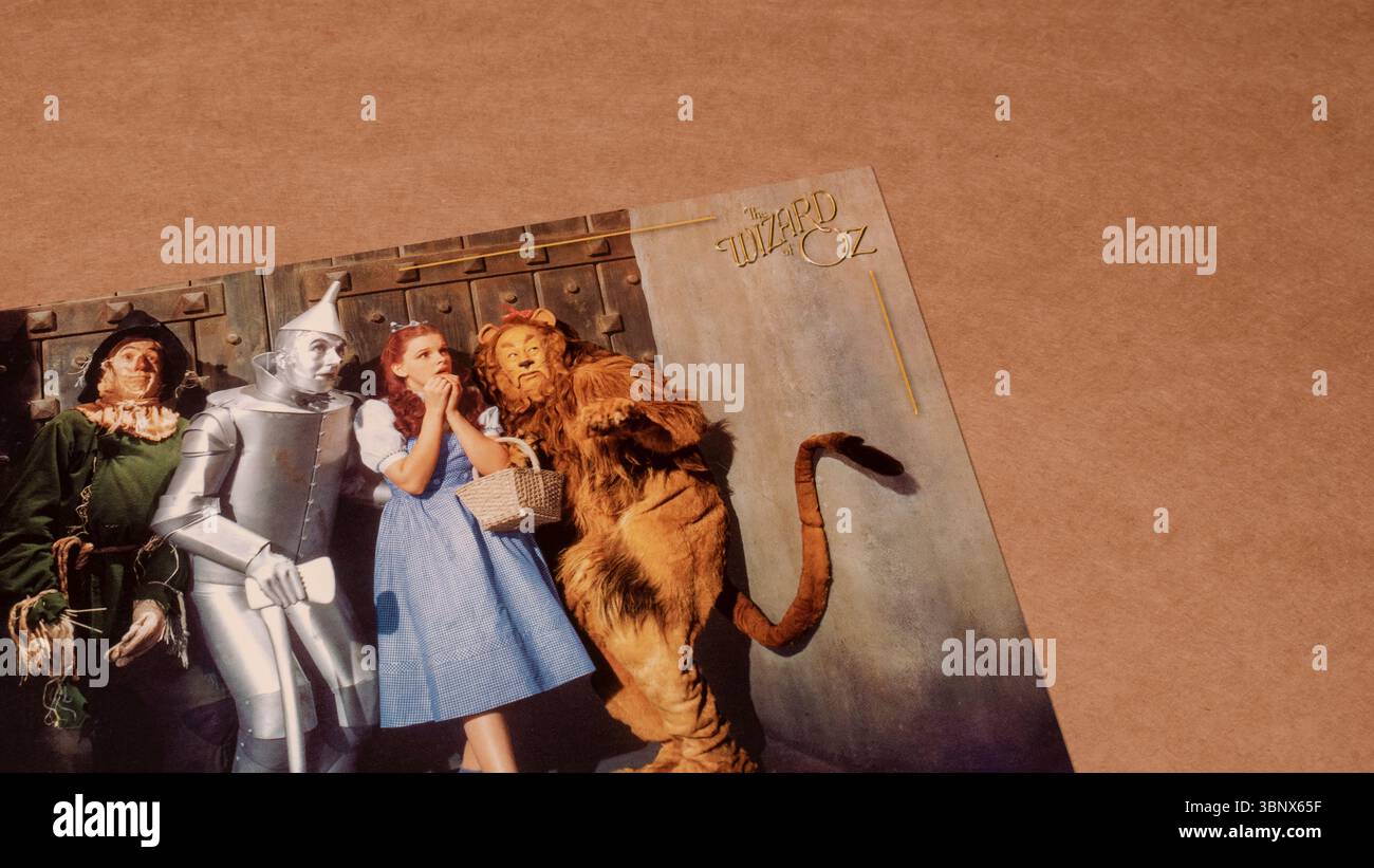 Carte postale « Wizard of Oz » représentant les personnages principaux regroupés devant la porte d'Emerald City, isolés sur fond de carton vierge Banque D'Images