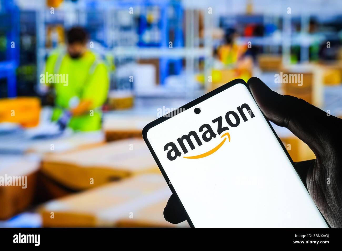 Ahmedabad, Gujarat, Inde. 4 juillet 2025. Dans cette illustration photo, le logo Amazon est bien visible sur l'écran d'un smartphone, avec un centre de distribution Amazon occupé en arrière-plan. (Crédit image : © Saurabh Sirohiya/ZUMA Press Wire) USAGE ÉDITORIAL SEULEMENT ! Non destiné à UN USAGE commercial ! Banque D'Images