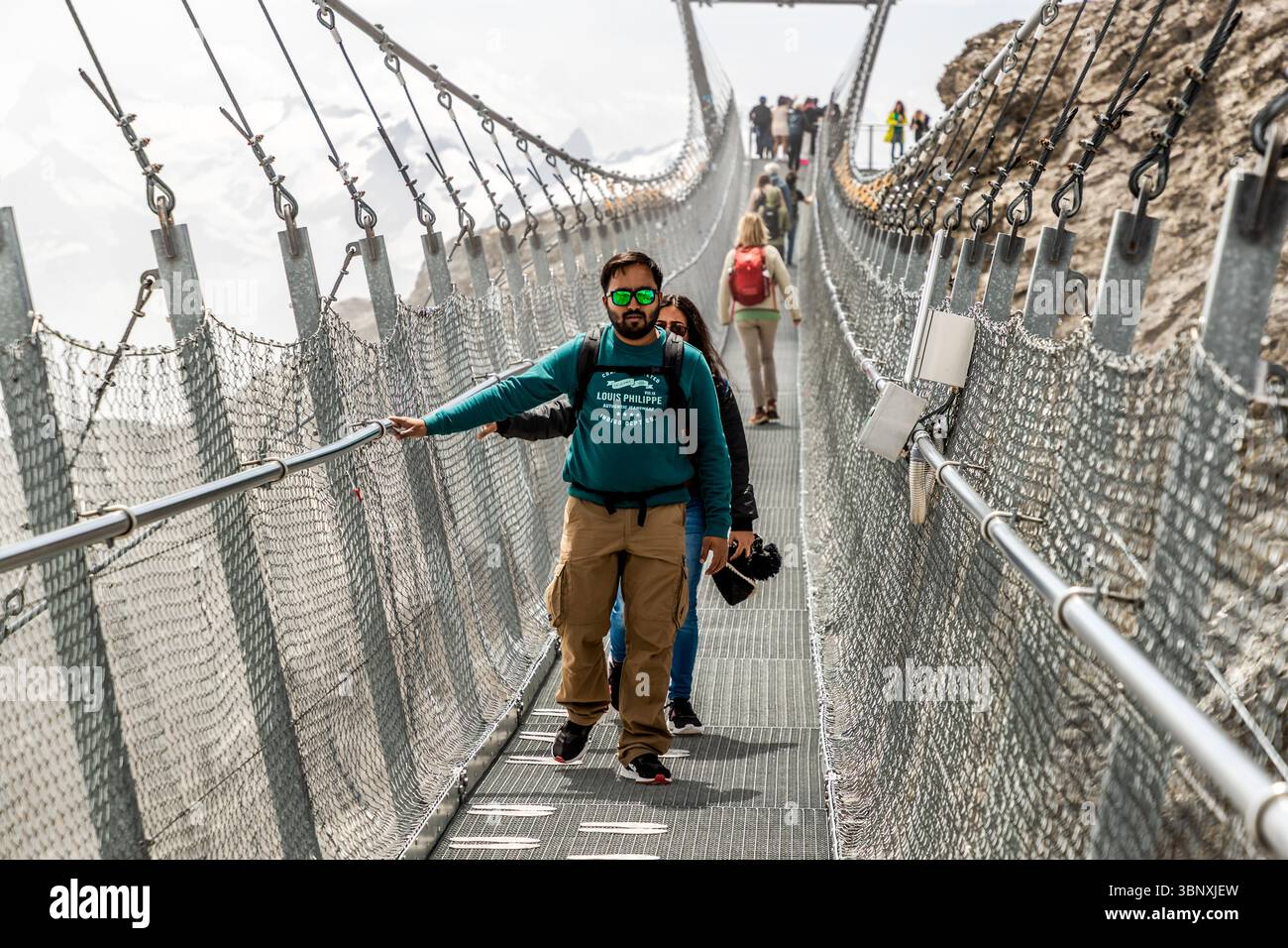 Titlis Cliff Walk, le plus haut pont suspendu d'Europe, à 3 041 mètres d'altitude, offre une vue imprenable sur un abîme de 500 mètres de profondeur. Les touristes traversent le pont suspendu Titlis Cliff Walk sur le Titlis à Engelberg, Obwald, Suisse. Ils apprécient l'expérience unique et la vue imprenable sur les montagnes environnantes en Europe Banque D'Images