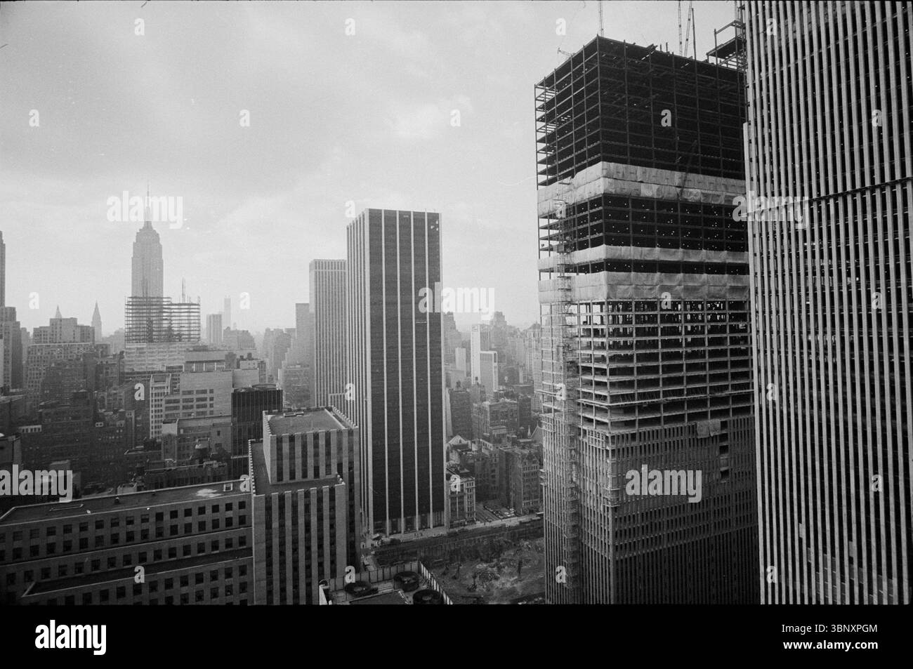 Photographie prise le 12 janvier 1971, montre la skyline de New York avec les tours jumelles du World Trade Center en construction au premier plan. L'Empire State Building se trouve bien en vue sur la gauche, avec d'autres gratte-ciel Midtown Manhattan remplissant la scène. Capturée par le photographe Thomas J. O’Halloran pour U.S. News & World Report, cette image historique documente le remodelage dramatique du Lower Manhattan au début des années 1970 Banque D'Images