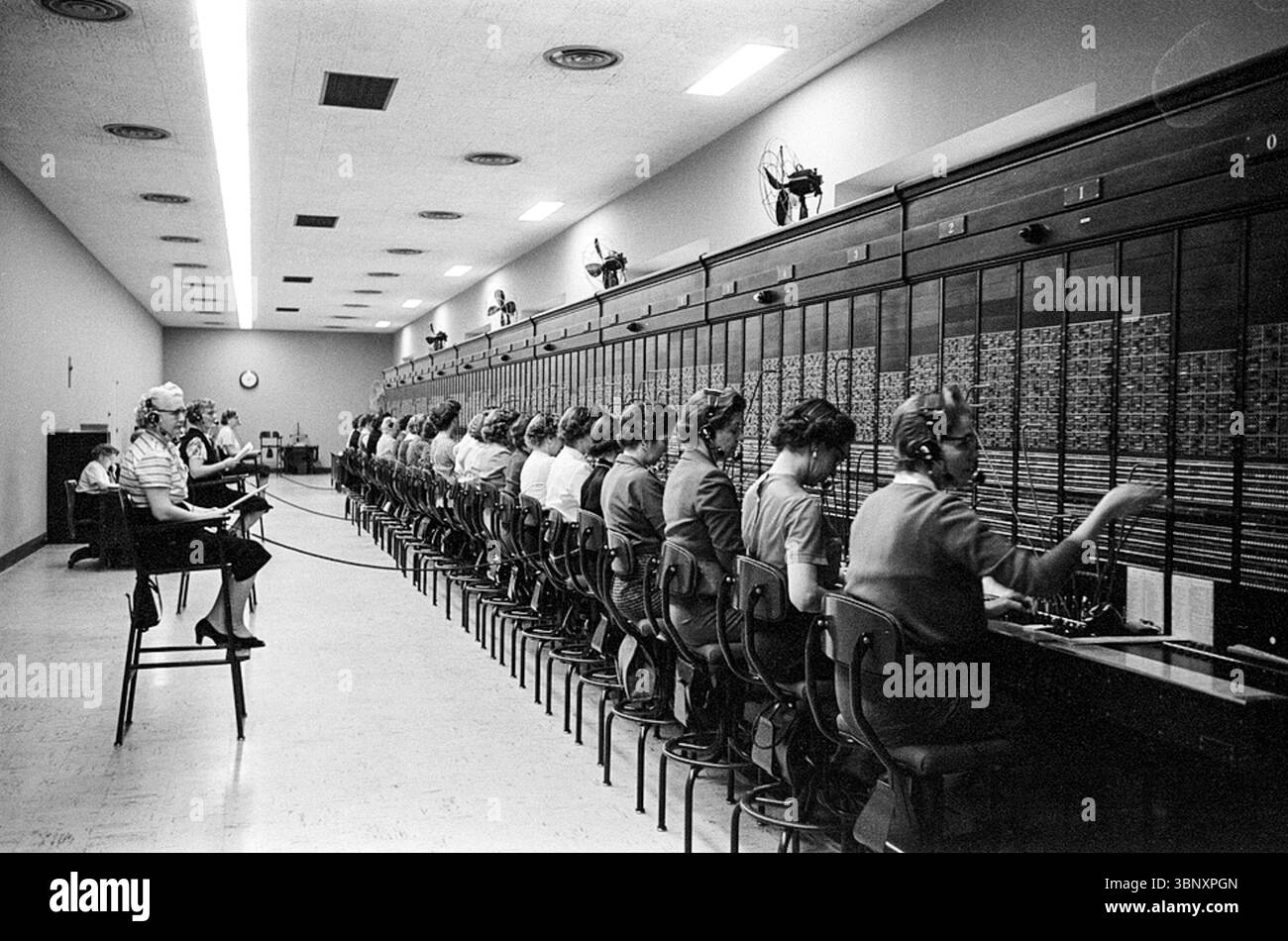 Photographie prise le 27 janvier 1959 par Marion S. Trikosko, montre une rangée de femmes opérateurs téléphoniques travaillant au standard du Capitole des États-Unis à Washington, D.C. en moyenne, elles traitaient 50 000 appels par jour, reliant les membres du Congrès et le public pendant une période occupée d'activité législative. Banque D'Images