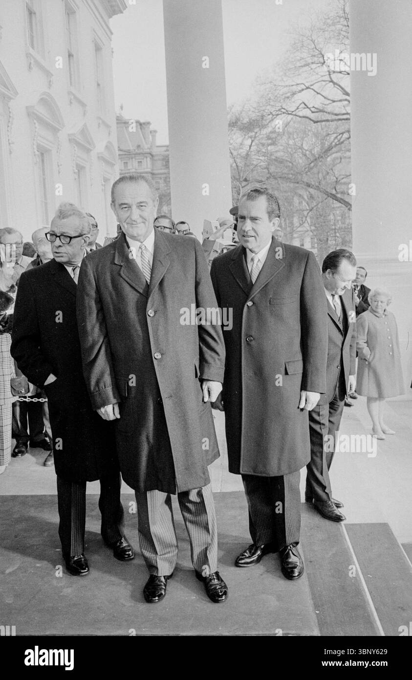 Le président Lyndon B. Johnson (au centre) et le président élu Richard Nixon (à droite) se tiennent ensemble devant la Maison Blanche le 20 janvier 1969, avant l’investiture de Nixon. Ce moment a capturé la transition du pouvoir à une époque de grands changements politiques et sociaux en Amérique. Banque D'Images