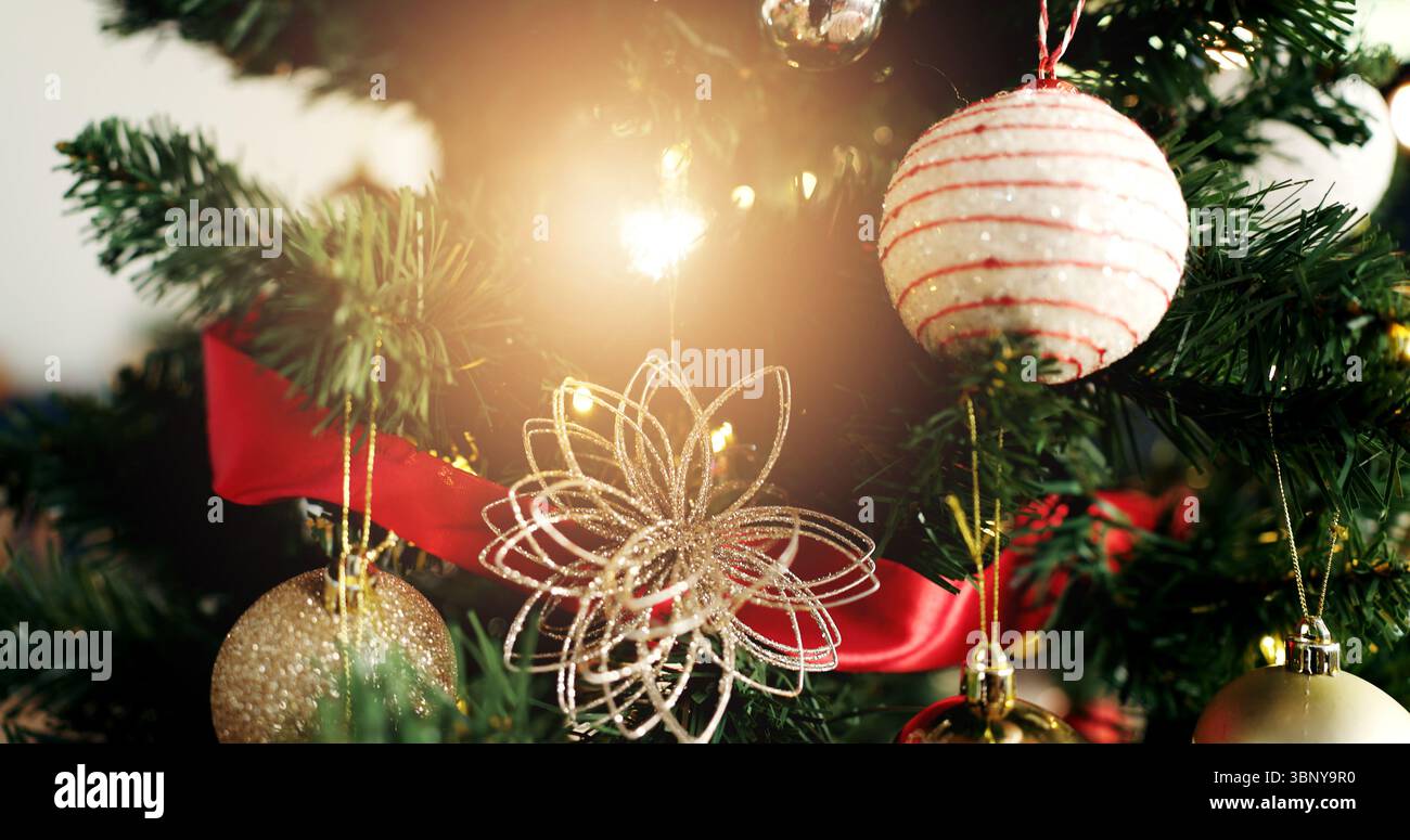 Noël, arbre et boule avec lumière pour les vacances festives, décembre ou célébration à la maison. Gros plan, objet ou décorations avec des ornements suspendus pour Banque D'Images