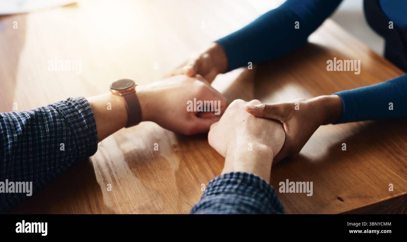 Empathie, se tenant la main et le soutien avec des personnes à la maison ensemble pour créer des liens, des confessions ou de l'amour. Aide, espoir et solidarité avec les amis à table In Banque D'Images