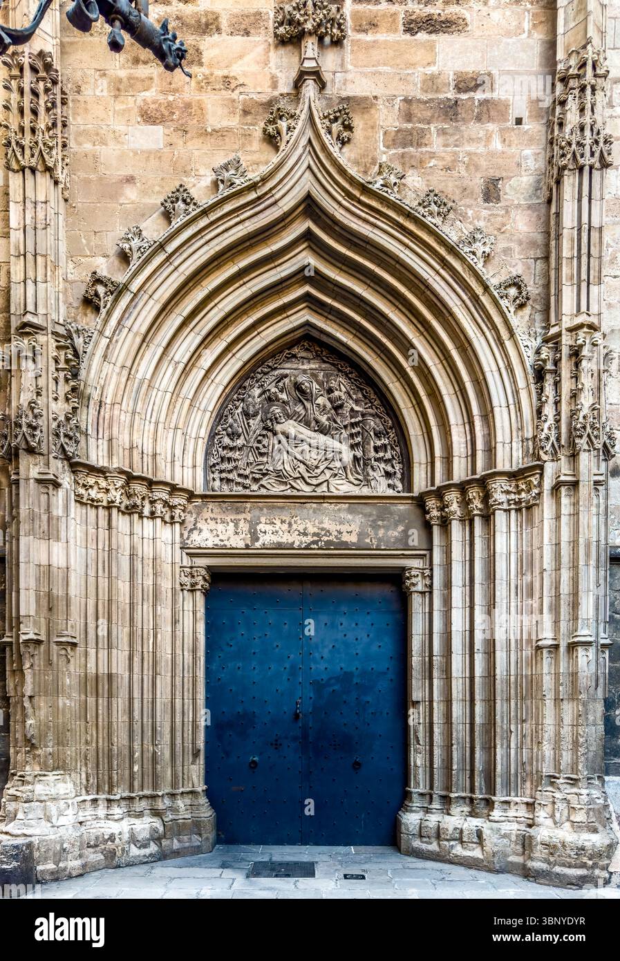 Le Portal de Sant IU, une porte gothique magnifiquement sculptée de la cathédrale de Barcelone, avec une porte bleutée, dans le quartier gothique, en Espagne. Banque D'Images