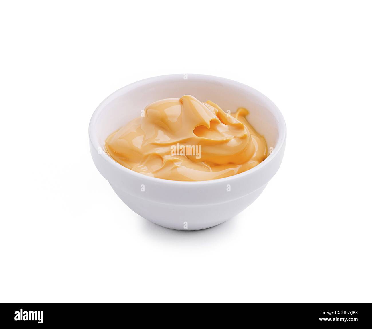 Nature morte, cette trempette à l'orange crémeuse est présentée dans un bol blanc simple, idéal pour compléter les collations lors de réunions ou de fêtes. Son textu lisse Banque D'Images