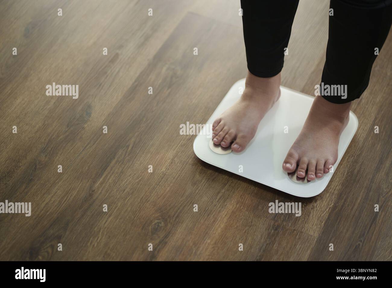 Pieds de femme debout sur des balances, concept de régime alimentaire Banque D'Images