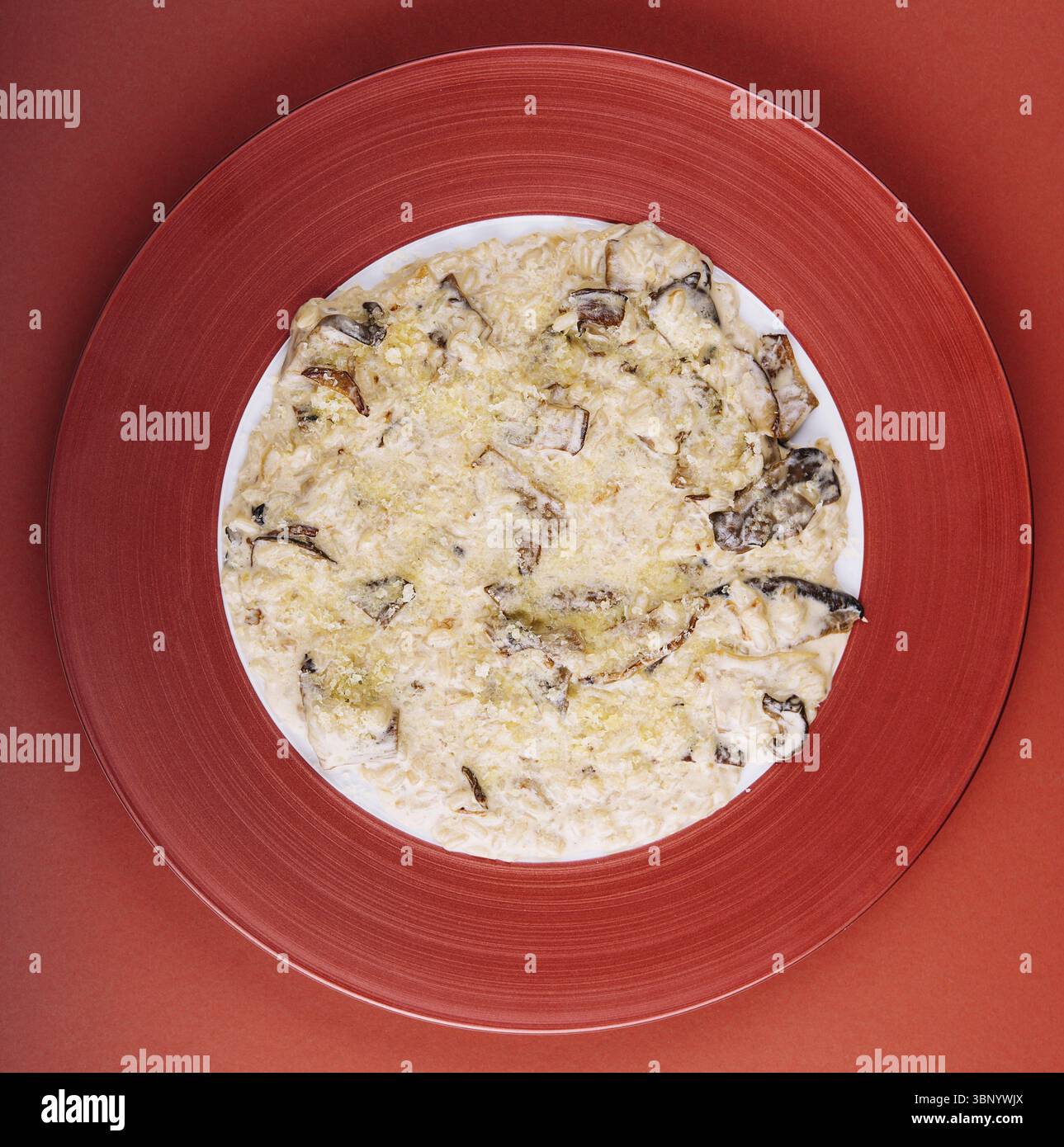 Nature morte, aubergines italiennes au parmesan sur assiette rouge Banque D'Images