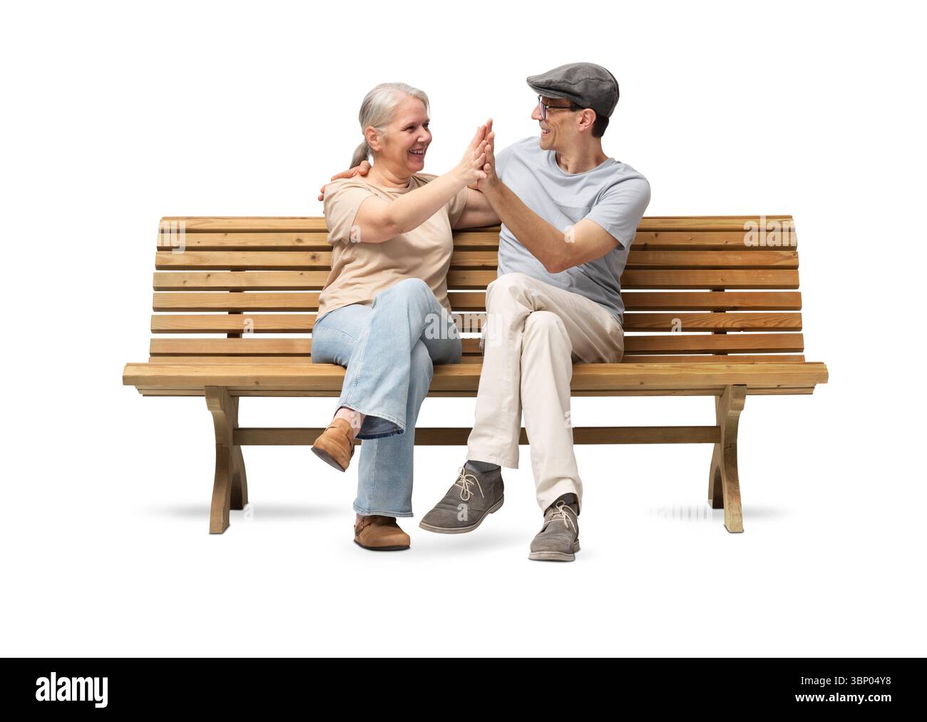 Heureux couple mature assis sur un banc en bois, embrassant et souriant avec joie. Un moment joyeux et affectueux ensemble. Studio shot isolé sur wh Banque D'Images