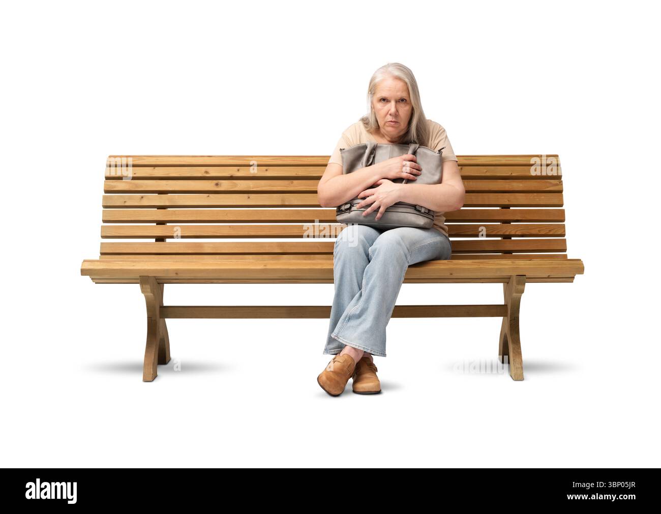 Femme mature effrayée assise sur un banc en bois, serrant son sac à main fermement avec une expression craintive. Concept d'insécurité, d'anxiété ou de peur du vol Banque D'Images