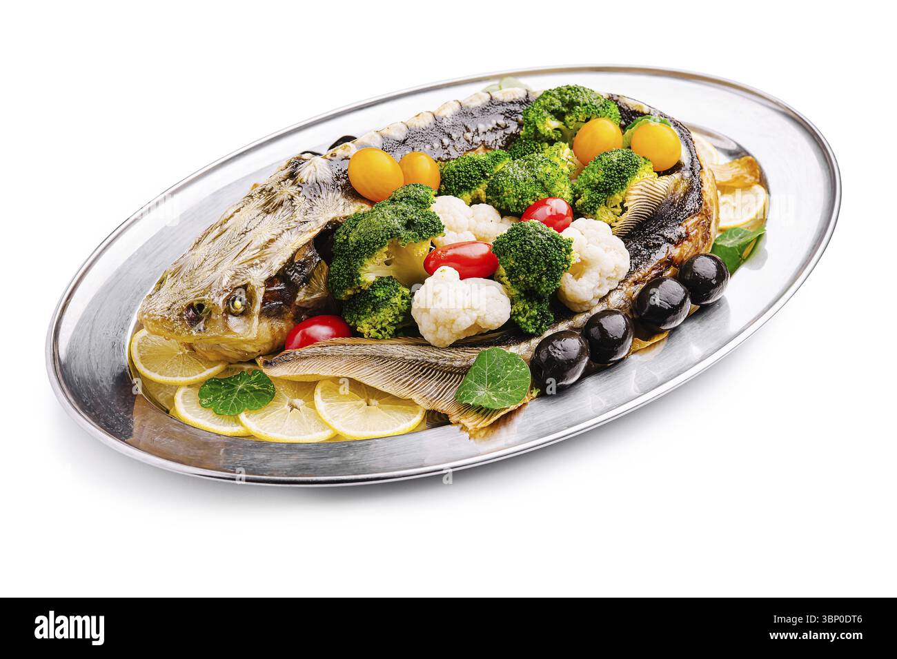 Nourriture morte-vie, Un poisson entier magnifiquement arrangé est servi sur un plateau d'argent. Il est garni de brocoli vibrant, de chou-fleur, de tomates colorées Banque D'Images