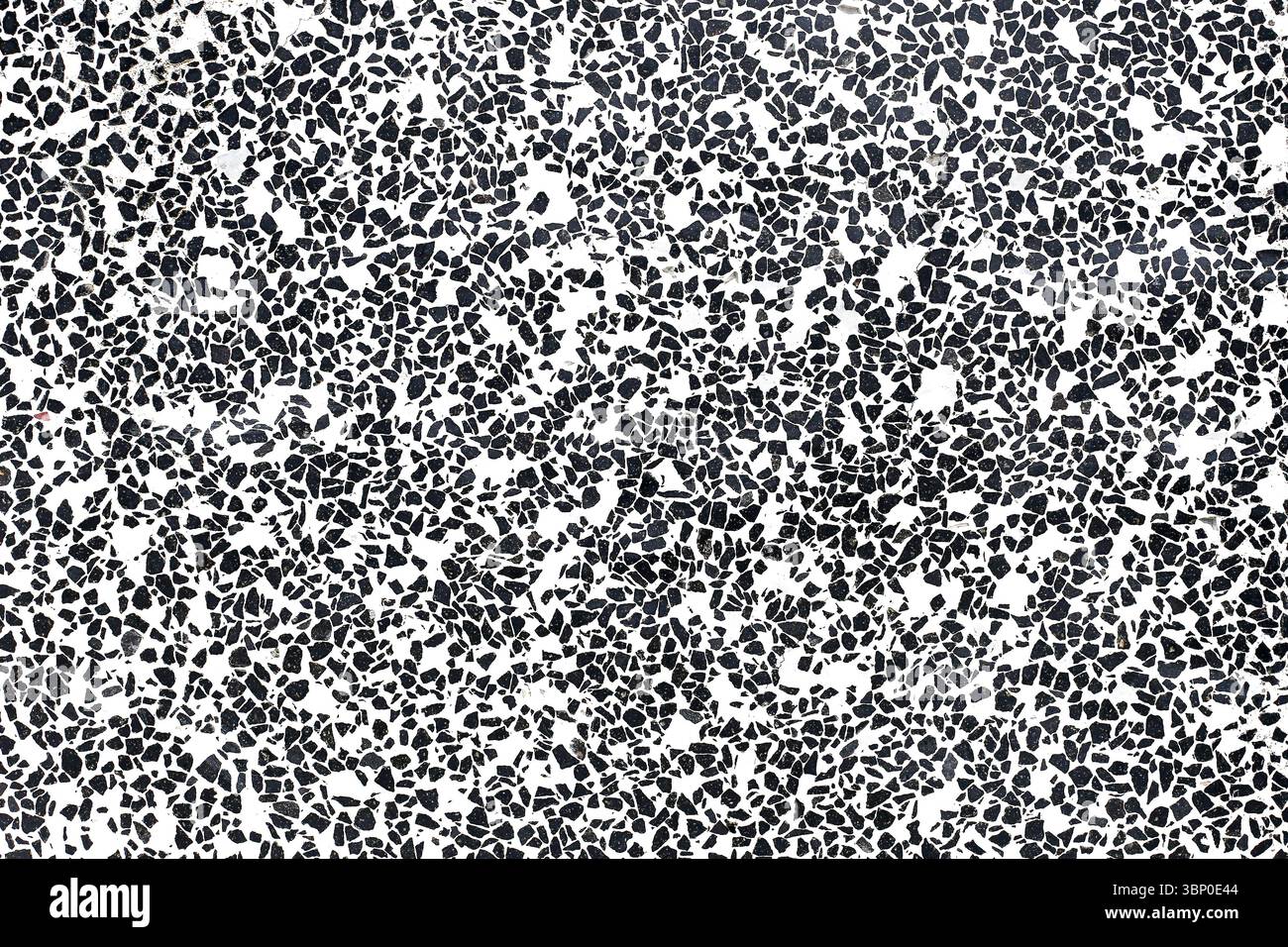 Surface terrazzo noire et blanche. Motif irrégulier d'éclats de pierre. Revêtement de sol ou texture murale minimaliste. Fond décoratif abstrait. Design moderne. Banque D'Images