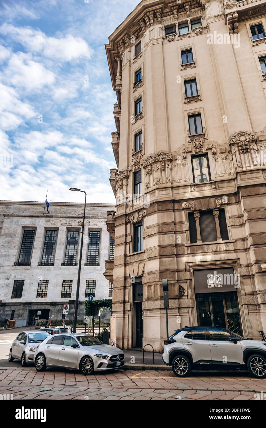 Milan, Italie - 19 mars 2025 : rue centrale de Milan avec bâtiments historiques, boutiques et scooters Banque D'Images