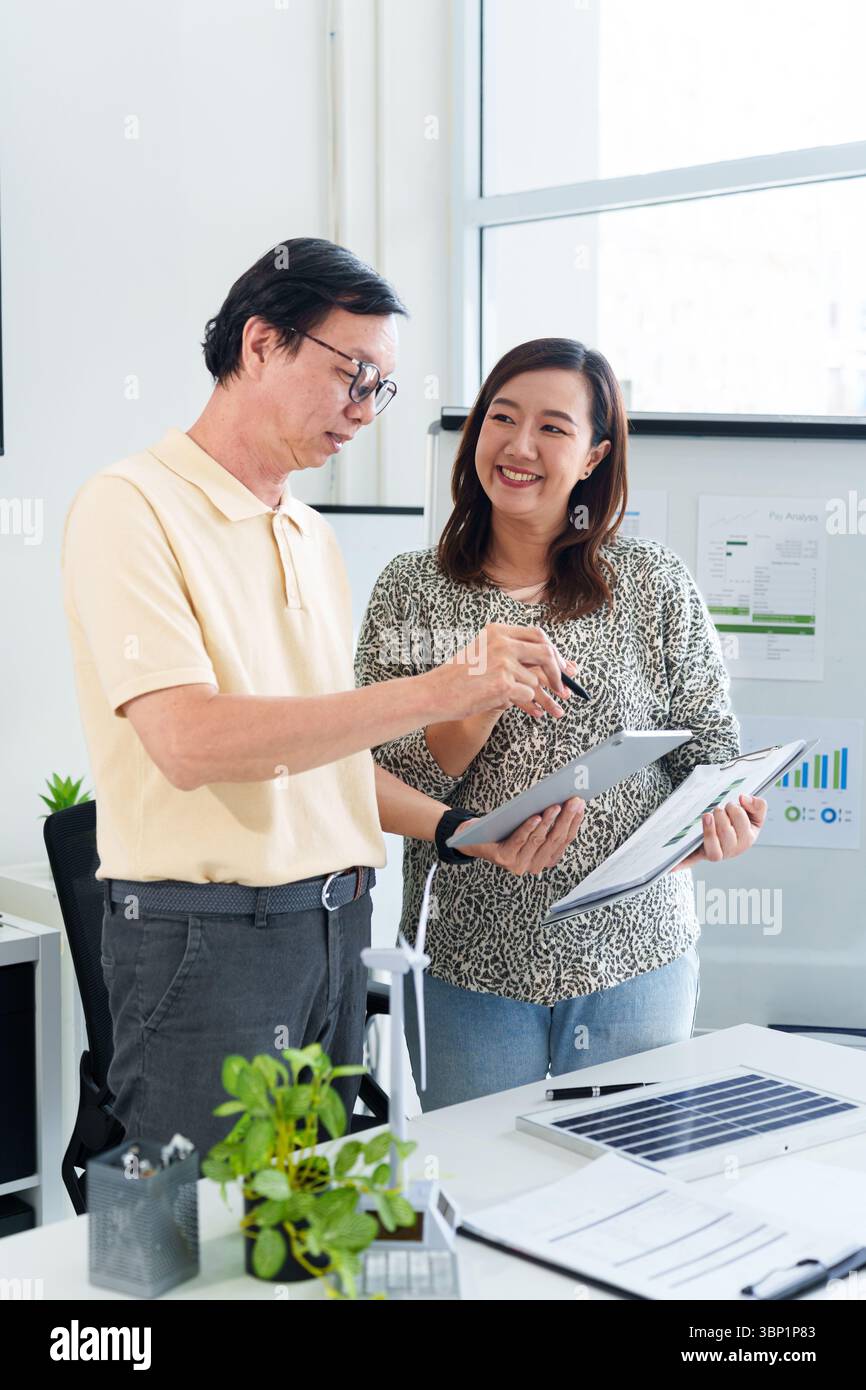 Deux adultes asiatiques planifient des pratiques commerciales durables axées sur les énergies renouvelables et la responsabilité sociale des entreprises Banque D'Images